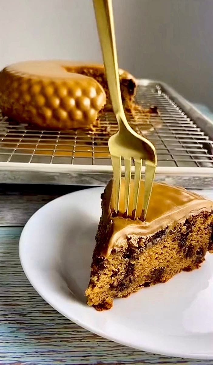 Place the cake on a wire rack to cool slightly then Heat up the jar of biscoff in the microwave or in a pan of simmering water and pour it over the cake . Any biscoff that drips down can later be used . Let the cake set then serve and enjoy