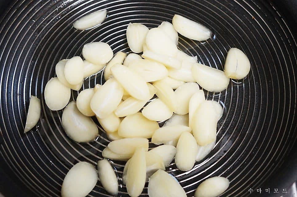 프라이팬에 식용유를 적당히 두르고 마늘슬라이스를 넣고 볶아주세요.