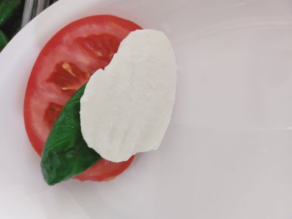 접시에 썰어둔 토마토와 바질, 모짜렐라 치즈를 올려 반복해서 쌓아주세요