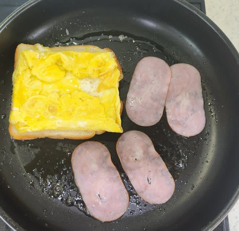 계란이 거의 익으면 식빵을 뒤집고 계란을 식빵 모양에 맞춰 접어 올려준 뒤 팬의 여유 공간에 햄을 올려 앞,뒤로 노릇하게 구워 주세요.