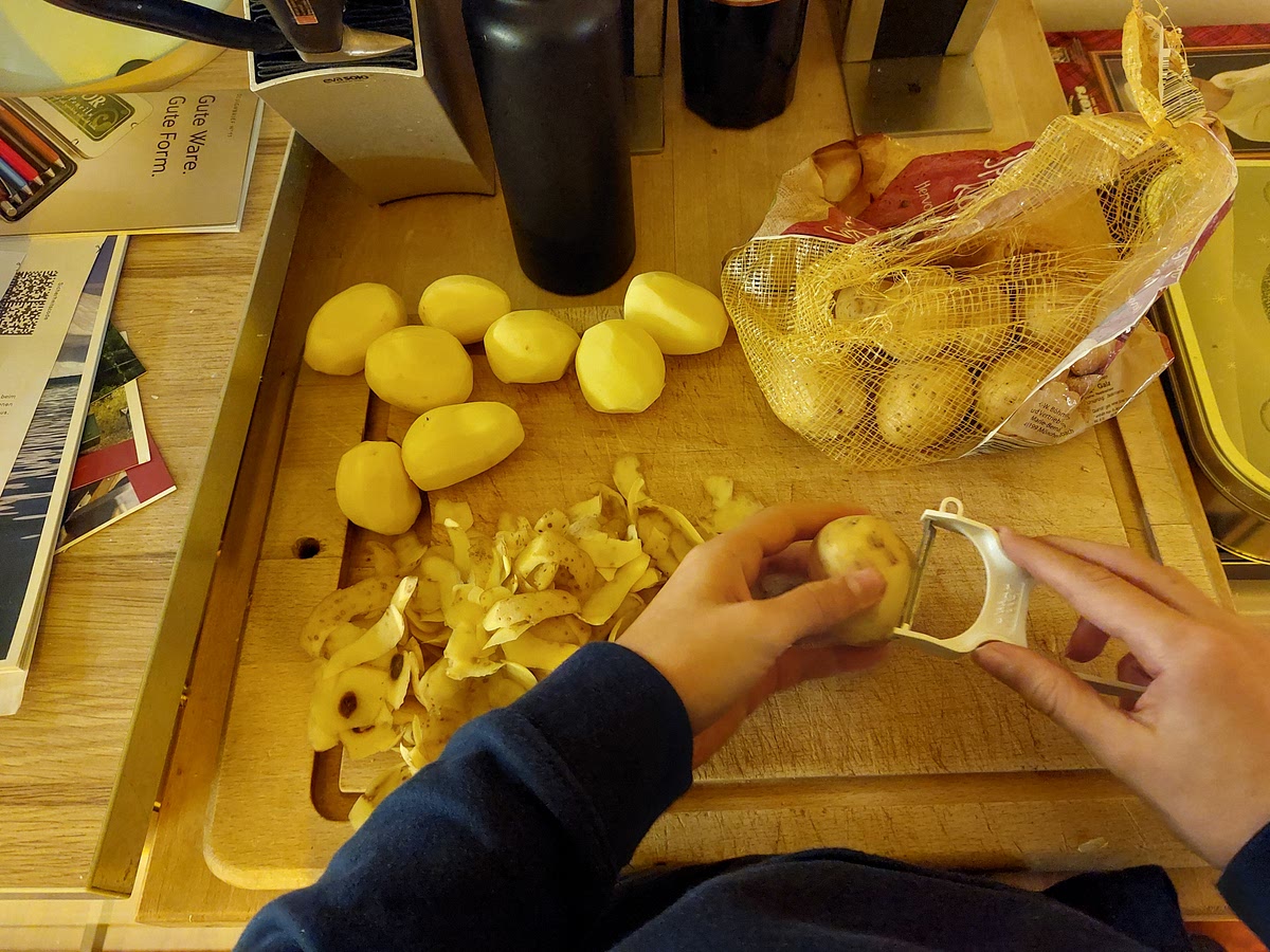 Kartoffeln schälen(, abspülen, trocken tupfen) und in dünne Scheiben schneiden