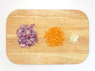 While the potatoes are cooking, reboil a kettle Peel and finely chop your red onion[s] Top, tail, and dice your carrot[s] Peel and finely chop (or grate) your garlic
