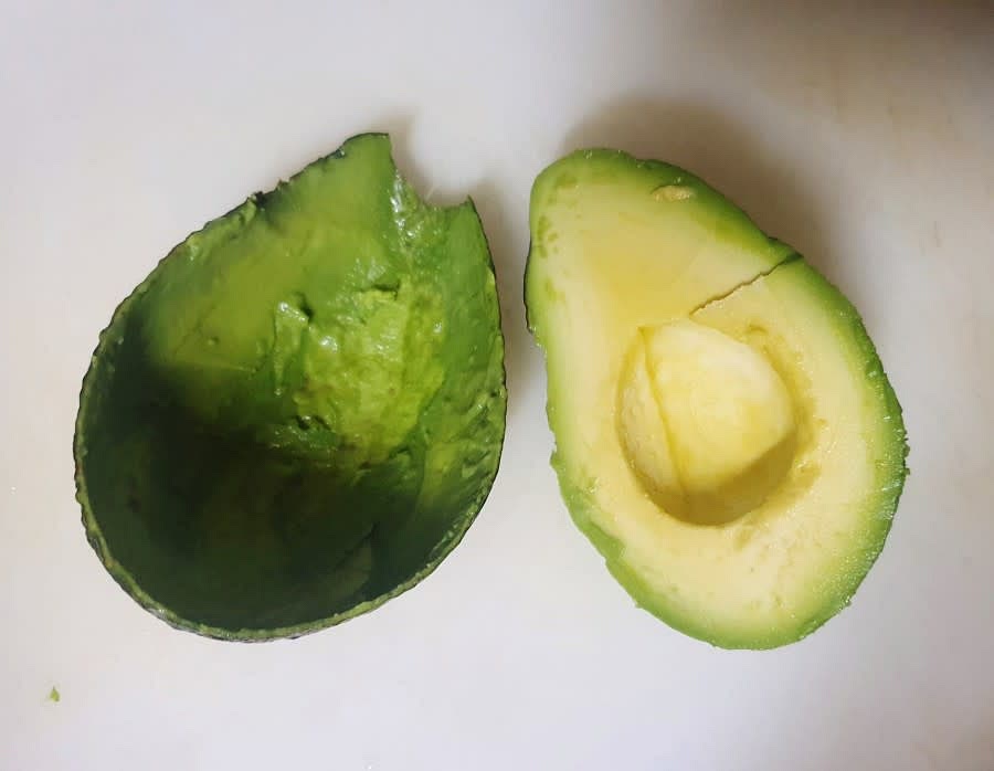 반으로 자른 아보카도의 가운데 씨앗을 칼로 콕 찍어서 빼내주세요. 그리고 숟가락을 이용해서 껍질을 분리시켜 주세요.