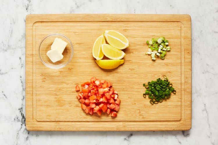 Quarter lemon. Trim and thinly slice scallions, separating whites from greens. Dice tomato into -inch pieces.