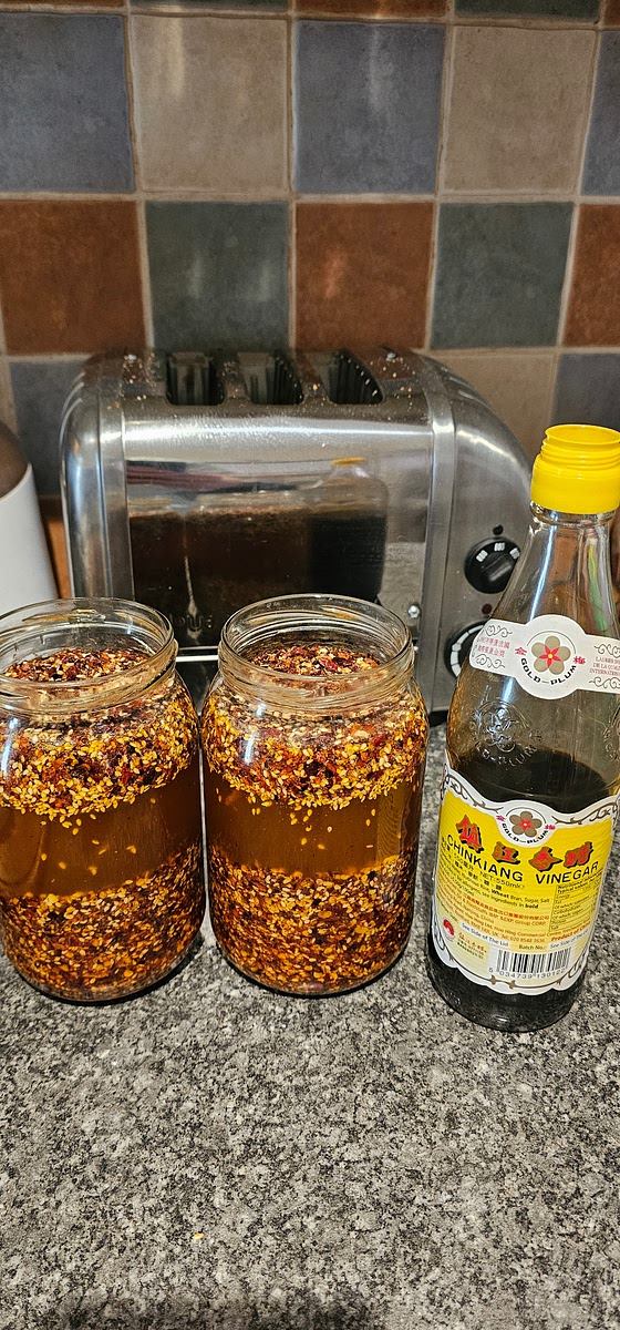 Once your jars are nicely topped to the rim with oil, the sesame seeds will float up and that is expected - they will always float! Now add 2 tbsp of chinese black vinegar into each jar and stir through. Be careful with all the bubbling at this stage as the cold liquid will react with hot oil and sizzle vigorously.