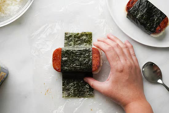 Lay one piece of nori so that it’s vertical from the Spam stack. It should look like a weird cross at this point.
