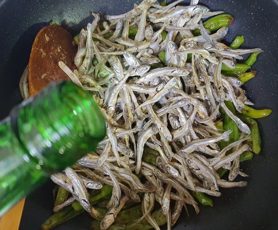 꽈리고추가 어느정도 숨이 죽으면 볶아놓은 멸치를 넣어줍니다. 그리고 멸치 잡내를 잡기 위해 술을 조금 부어주었어요.