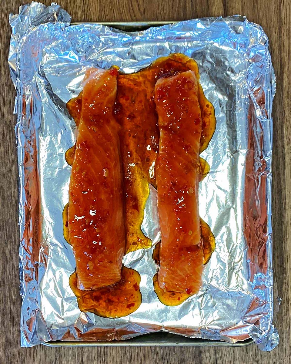 Put the salmon fillet onto a lined baking tray. Pour the chilli sauce mixture over the salmon.