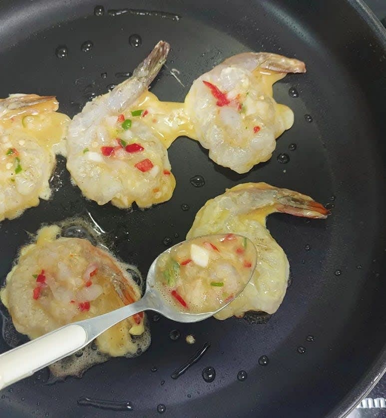 약불로 달군 팬에 계란물 입힌 새우를 올린 뒤 가운데 빈공간에 새우전 반죽을 한숟가락 떠서 올려 줍니다.