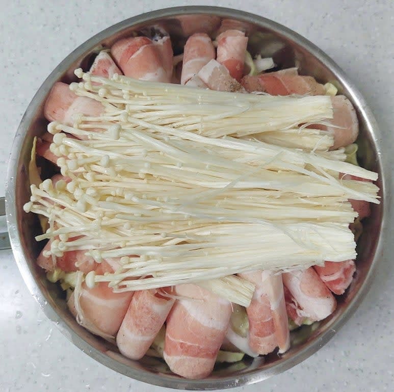 이 위로 남은 양배추,양파,대패삼겹살을 같은 방법으로 쌓아 올린 뒤 팽이버섯을 맨 위에 올려 주세요.