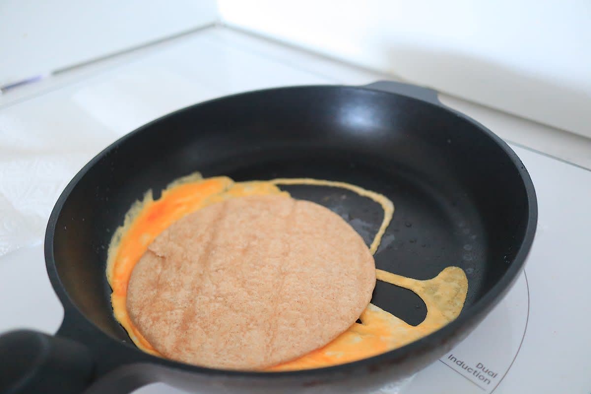 달걀이 다 익기 전 또띠아를 올리고, 달걀과 또띠아가 붙으면 뒤집는다.