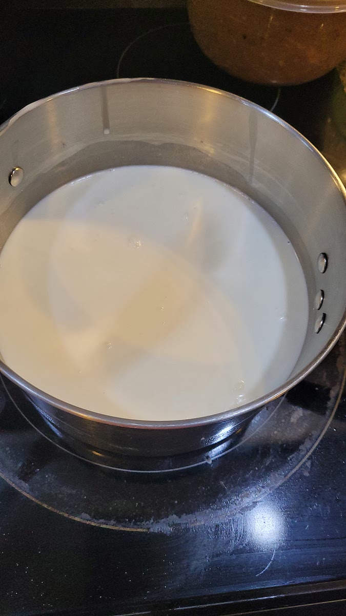 In a large sauce pan, over medium heat, bring milk, cream and salt to a boil. Stir frequently to keep from scorching.