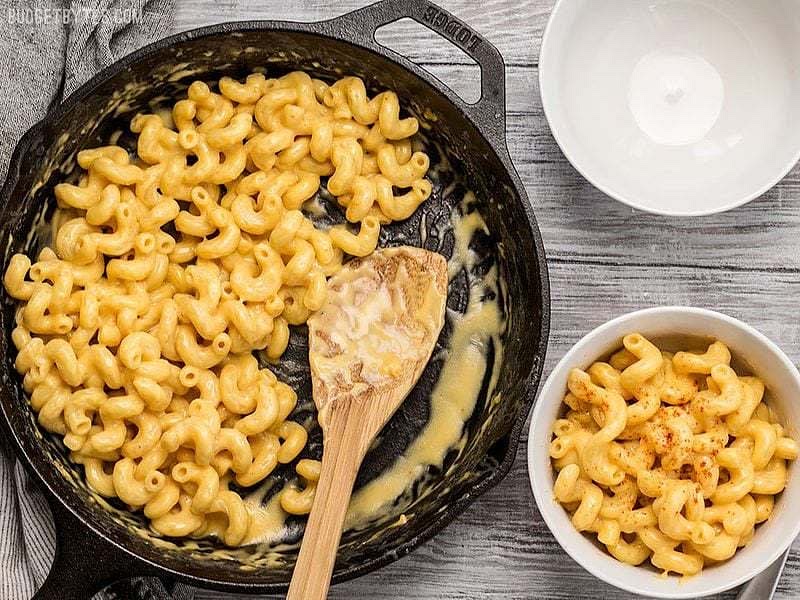 Add the strained pasta into the cheese mix and fold it in together. Mix it all together until the pasta is coated with the cheese mix.