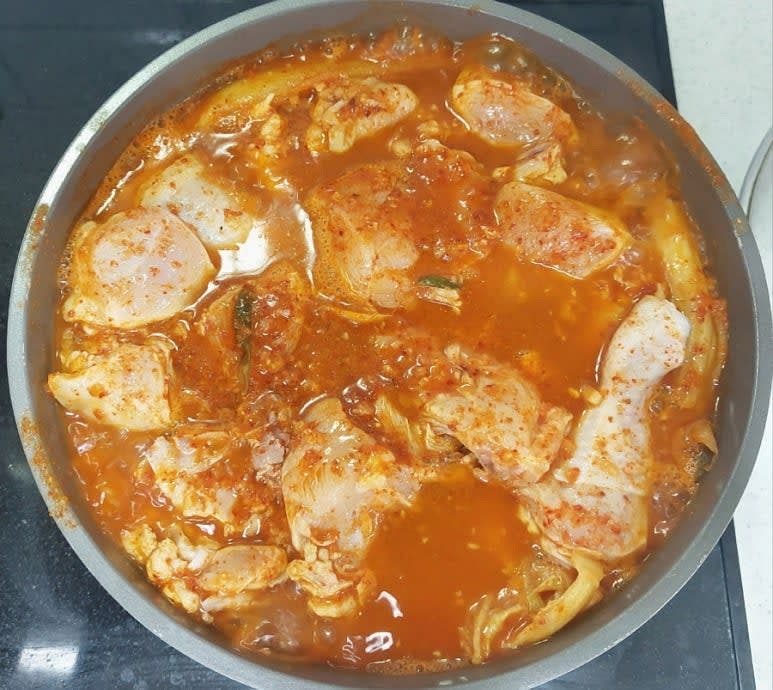 냄비 바닥에 자른 김치를 깔고 그 위에 닭을 넓게 펼쳐 담고 물 300ml와 양념을 모두 넣고 뚜껑을 덮어 중불로 20분 끓여 주세요.