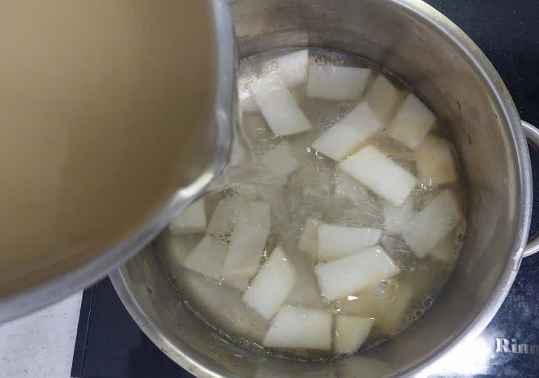 냄비에 참기름 1스푼과 무를 넣고 약불에 볶다 무의 겉면이 살짝 익으면 멸치육수 1.1L를 부은뒤 중불로 10분 끓여 주세요.