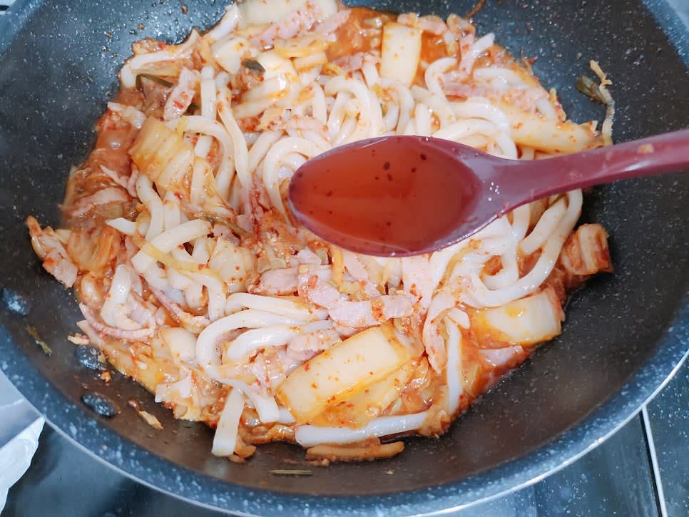 국물이 끓으면 우동 면사리와 참기름 1큰술을 넣고 볶아주세요. 완성되면 그릇에 깨와 김가루를 올려주세요