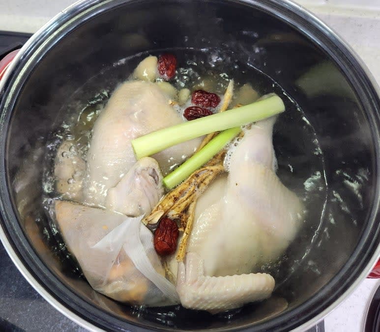 냄비에 닭과 대파 흰부분 두대 , 삼계탕용 한방 재료 1팩 그리고 함께 들어 있는 황기와 대추 ,마늘 10개 ,편생강 한쪽과 물 2L를 넣어 뚜껑을 덮고 중불로 50분간 끓여 줍니다.