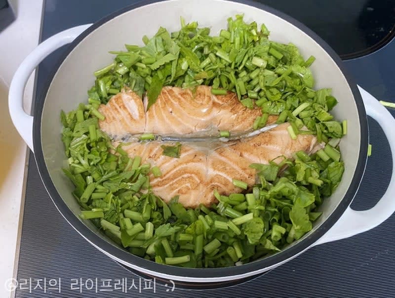 물이 졸아들면 구운 연어를 얹고 뚜껑을 닫아 약불에서 10분정도 끓여준뒤, 뚜껑을 열어 미나리와 쪽파를 얹고 약 12분정도 뜸들여주세요