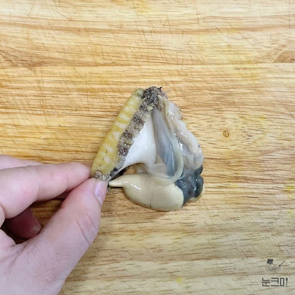 끓는 물에 전복을 넣은 뒤 20초 정도 데쳐준 뒤 숟가락을 입 부분에 넣어 껍질과 분리한 뒤 내장을 잘라내 줍니다.