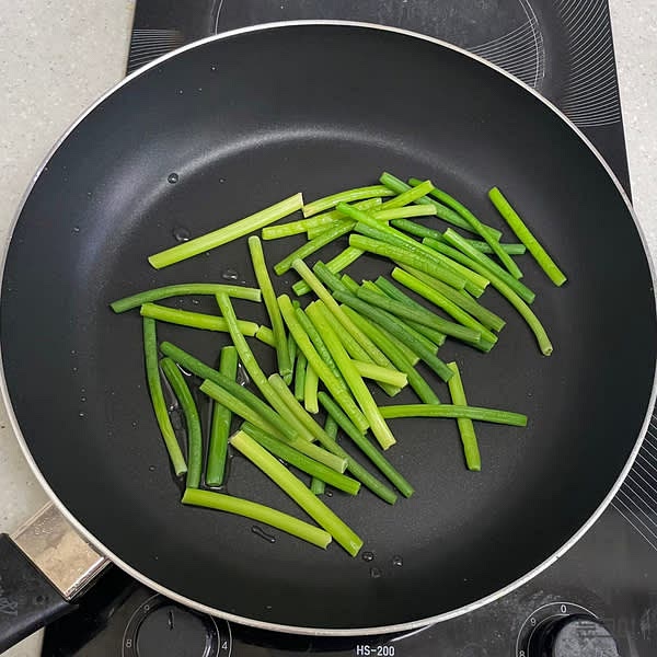 팬에 식용유 1큰술을 두르고 마늘쫑을 넣은 뒤 중약불에서 30초 정도 볶아줍니다.