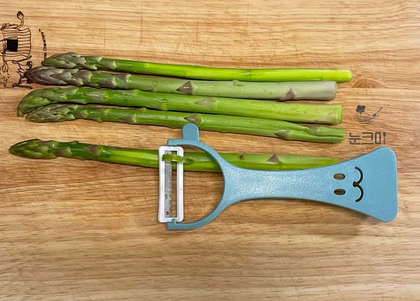 아스파라거스는 흐르는 물에 깨끗이 세척한 뒤 밑둥을 1~2cm 정도 잘라준 뒤 감자용 필러를 이용해 속살이 나오도록 껍질을 벗겨줍니다.