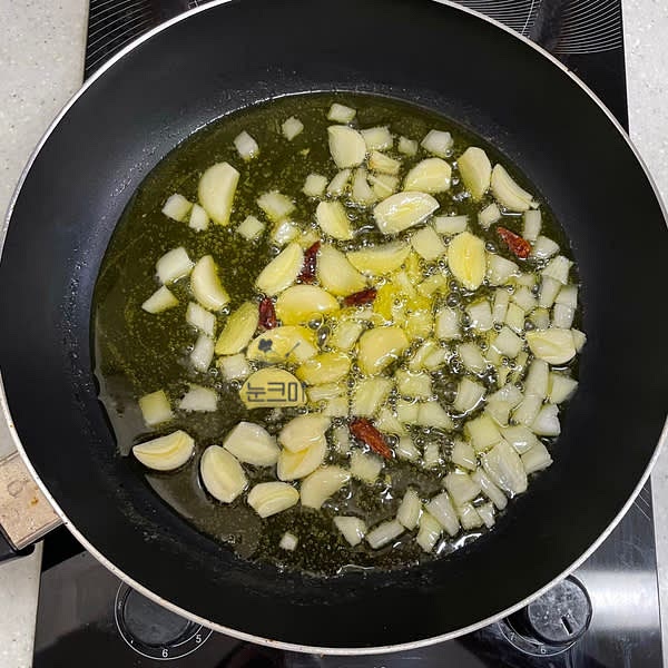 오일이 끓어오르기 시작하면 페페론치노를 넣어준 뒤 중약불을 유지하면서 마늘이 노릇노릇 해질 때까지 튀기듯 익혀줍니다.