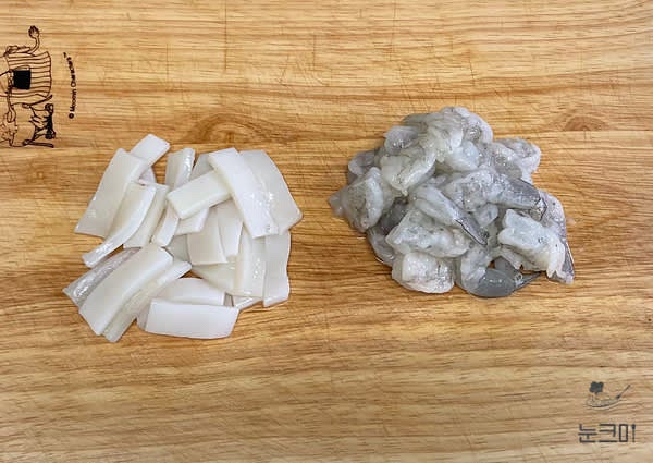 오징어는 흐르는 물에 깨끗이 세척한 뒤 0.5cm 정도의 두께로 썰고 반으로 잘라주고 냉동새우는 찬물에 해동 후 꼬리는 제거하고 반으로 잘라줍니다.