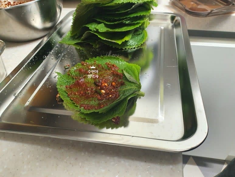 세척해둔 깻잎의 수분을 탈탈 털어서 준비해서 넓은 트레이를 이용해서 깻잎 두장당 한숟가락 정도의 양념을 묻혀준다