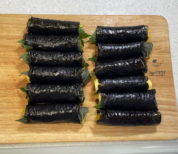 말아주기 전 달걀 흰자를 밥이 없는 끝 쪽에 발라준 뒤 돌돌 감싸 말아주고 윗면에 참기름을 발라주고 통깨를 뿌려주면 완성해 줍니다.