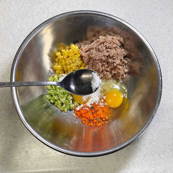 넓은 그릇에 야채와 옥수수콘, 참치를 넣어주고 달걀 2개, 부침가루 1큰술, 소금, 후추를 넣어 잘 섞어줍니다.