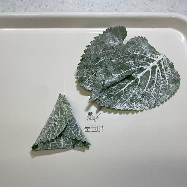 깻잎 안쪽에 만두소를 넣고 깻잎의 밑부분을 올린 뒤 왼쪽과 오른쪽을 접어 삼각형 모양을 만들어 줍니다.