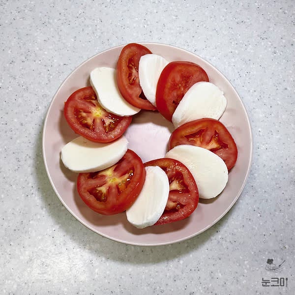 넓은 접시에 토마토와 생모짜렐라치즈를 하나씩 번갈아 담아 동그랗게 모양을 만들어 줍니다.