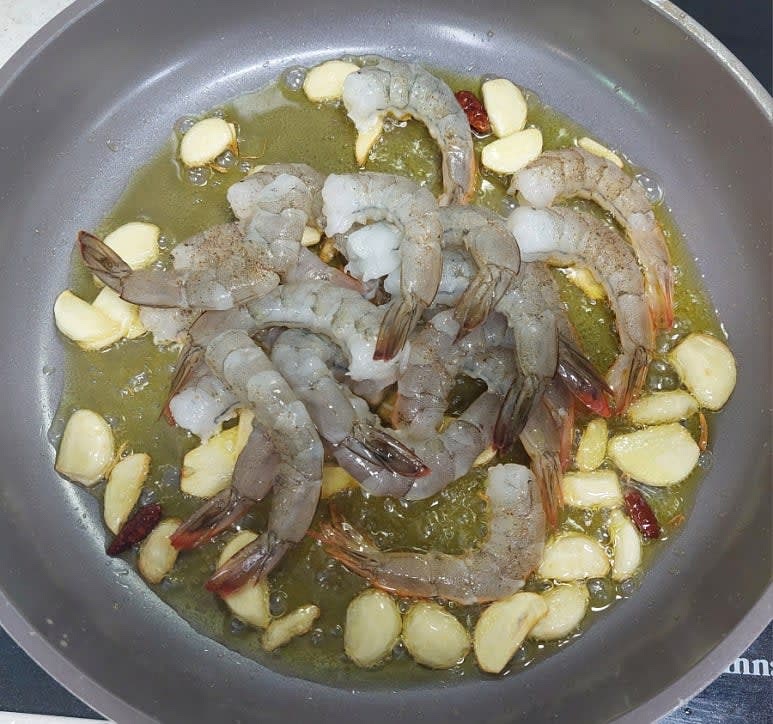 달군 팬에 올리브 오일 8스푼을 두르고 마늘과 페페론치노 3개를 넣어 볶다 마늘이 노릇해지면 새우를 넣어 주세요.