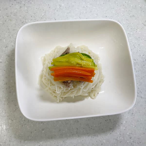 그릇에 국수를 또아리 틀어서 담아준 뒤 고명을 차례대로 올려주고 육수를 부어 완성해 줍니다.