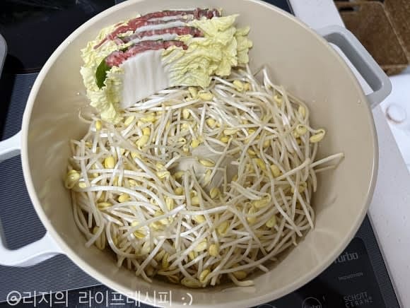 쌓은 고기와 배추를 냄비 높이에 맞춰서 잘라주시고, 냄비 밑에 콩나물을 먼저 깔아주세요