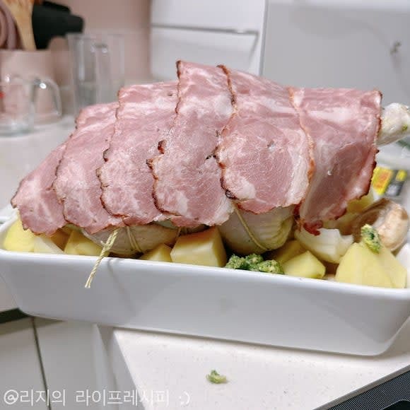 오븐사용가능한 그릇에 감자와 양파, 양송이버섯을 깐 뒤에 닭을 올려주세요. 그 위에 베이컨으로 닭을 덮어주세요