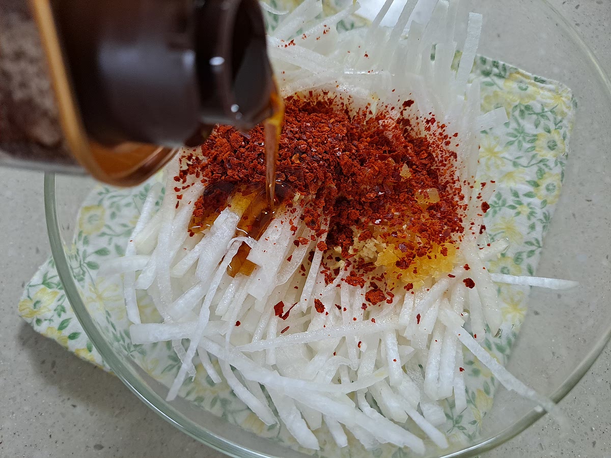 무는 채썰어 설탕,소금,까나리액젓,다진마늘,다진생강,굵은고추가루를 넣고 고루 버무려 무쳐줍니다.