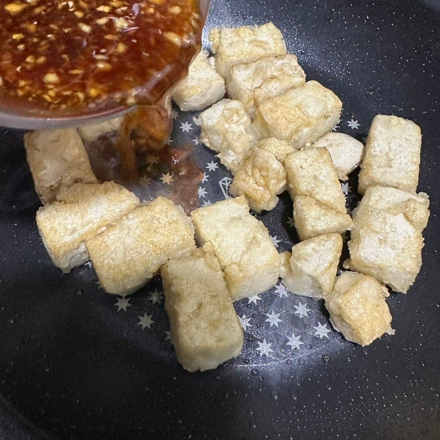 두부가 노릇하게 구워지면 남은 기름을 가볍게 닦아내고 준비한 양념을 부어주세요.