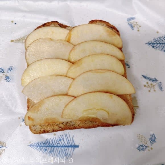 랩을 깔아준 뒤에 식빵을 올리고, 땅콩버터를 바르고 사과를 얇게 썰어서 올려주세요