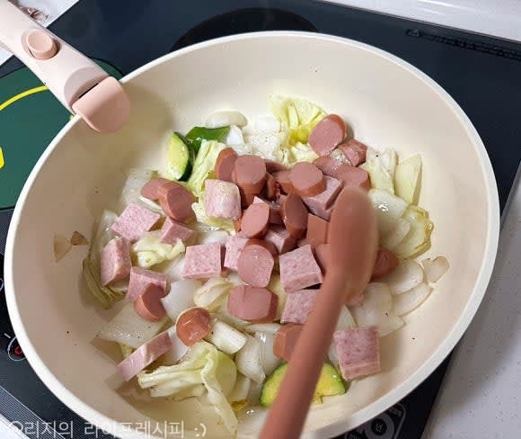 예열된 팬에 식용유를 넣고 양파와 양배추를 먼저 볶다가, 추가로 다른 야채들도 넣어 볶아주고 소세지와 햄도 넣어 볶아주세요. 다진돼지고기도 같이 넣어 볶다가 후추도 넣어주세요