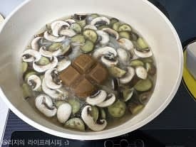 양송이버섯도 넣은 뒤 고체카레를 넣고 잘 풀어주며 끓여주세요. 그 사이에 다른 팬에 식용유를 듬뿍 부어 끓인뒤, 편마늘을 넣고 마늘칩이 되도록 튀겨주세요
