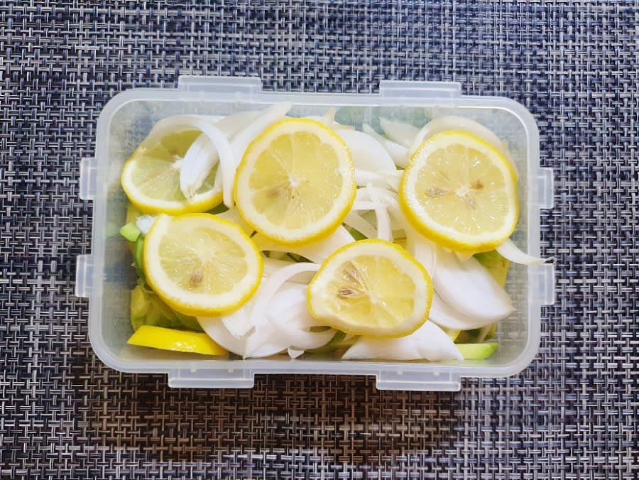 락앤락통에 썰어 놓은 아보카도를 넣고 그 위에 양파와 레몬을 올려주세요.