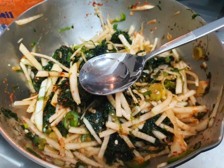 파래에 무와 대파를 넣고, 파래는 손으로 찢으면서 분량의 조선간장, 설탕, 식초, 고춧가루, 소금을 넣고 조물조물 무쳐서 통깨를 넣어 마무리한다.