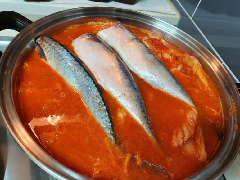 냄비에 묵은지를 넣고 김치국물 2국자와 고춧가루 1큰술, 다진마늘 1큰술, 다진생강 0.5큰술, 국간장 1큰술, 된장 0.5큰술, 매실액 3큰술을 넣고 물을 부은 후 고등어를 올린다.