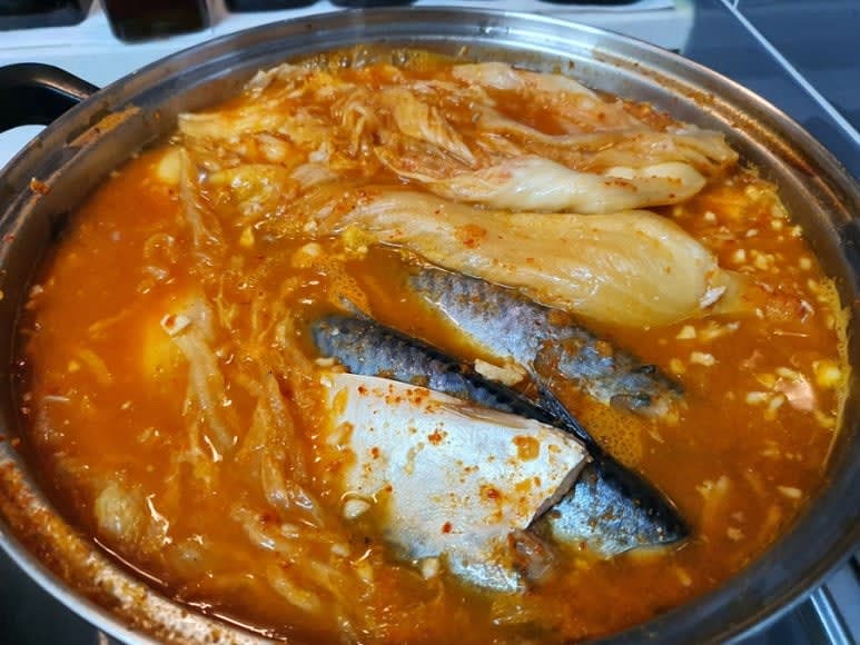 김치가 부드러워지면 고등어 위에 국물을 끼얹어 배어들도록 한다.