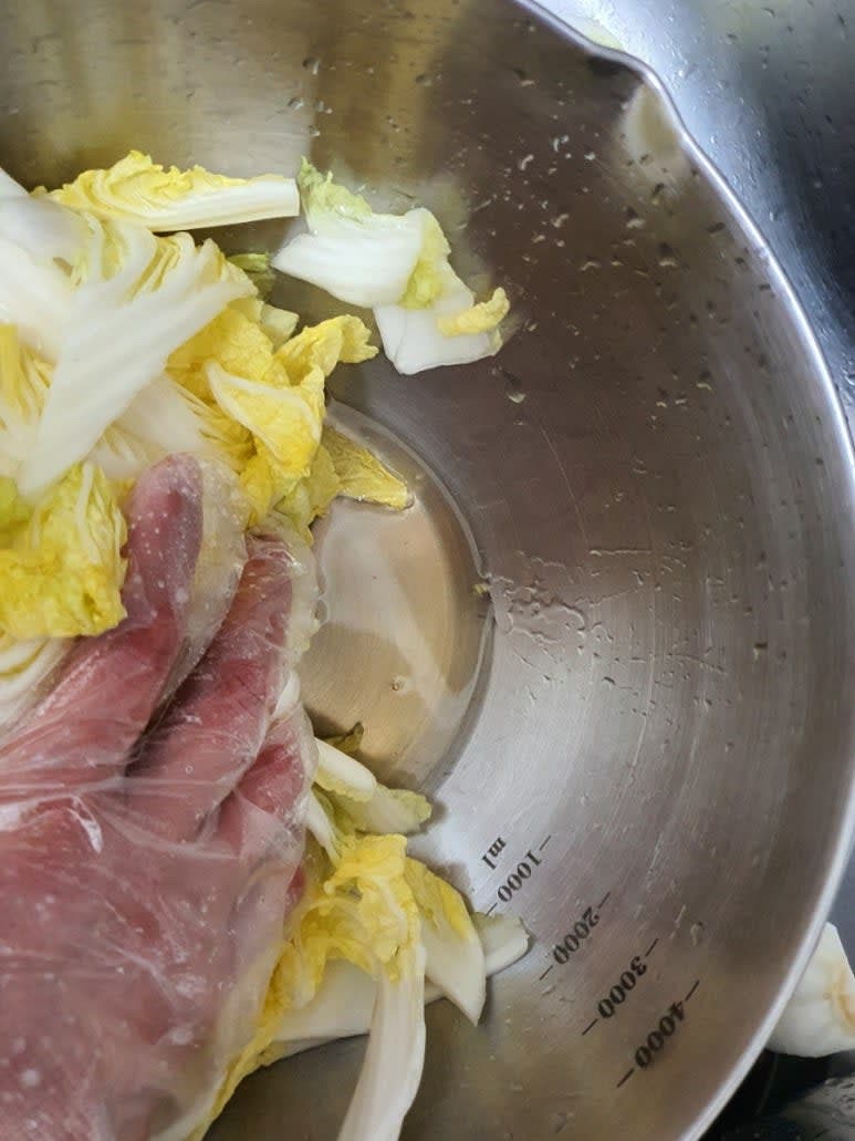 절여진 배추에서 생긴 물을 버리고 고춧가루 2큰술, 다진마늘 0.5큰술을 넣고 버무려줍니다.