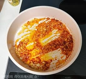 예열된 팬에 식용유와 들기름을 같이 넣어주고, 다진마늘을 볶아주다가 약불로 줄여 고춧가루도 넣고 잘 볶아주세요