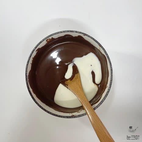 중탕한 초콜릿에 데운 생크림을 3번 정도 나누어 넣고 잘 섞은 뒤 냉장고나 냉동실에 넣어 적당한 농도로 굳혀줍니다.