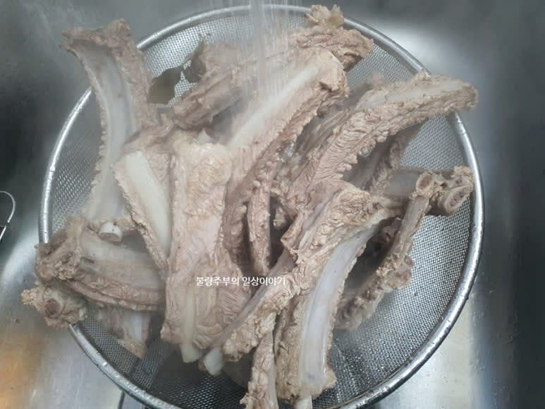 겉면에 핏기가 없어졌으면 등갈비를 찬물에 깨끗이 헹구고 체반에 받쳐둡니다.