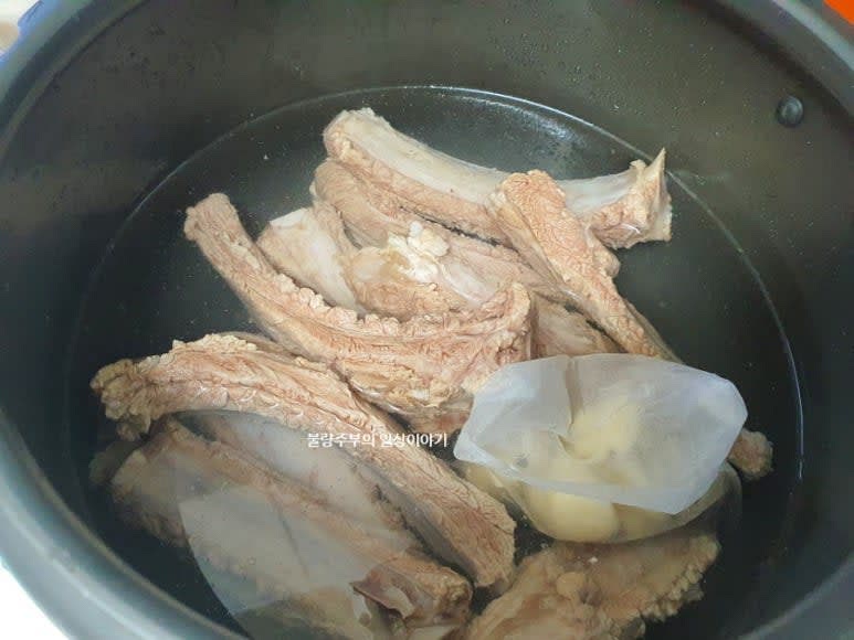 압력솥에 등갈비를 넣고 잠길 정도로 물을 붓고, 통후추와 통마늘을 육수팩에 담아 함께 넣고 끓여줍니다.